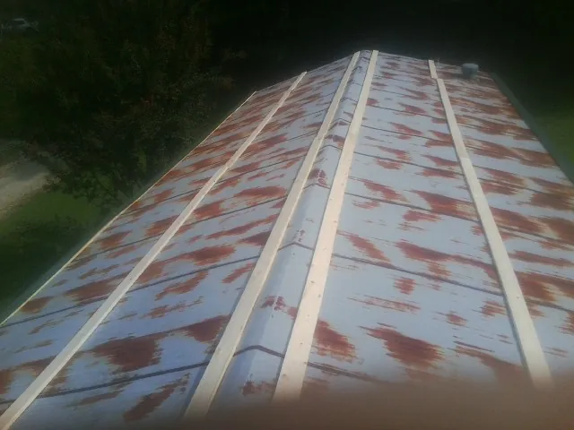 Rusted metal roof panels with new wood purlins before replacement — Storm Damage Roof Repair in Okemos by Roofing Brothers